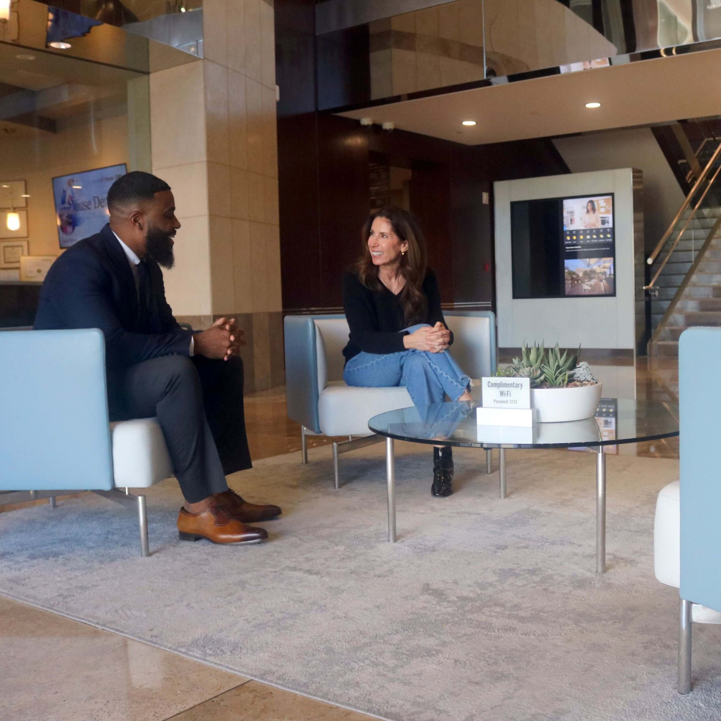 Two professionals discussing engineering and consulting solutions in a modern office lobby.