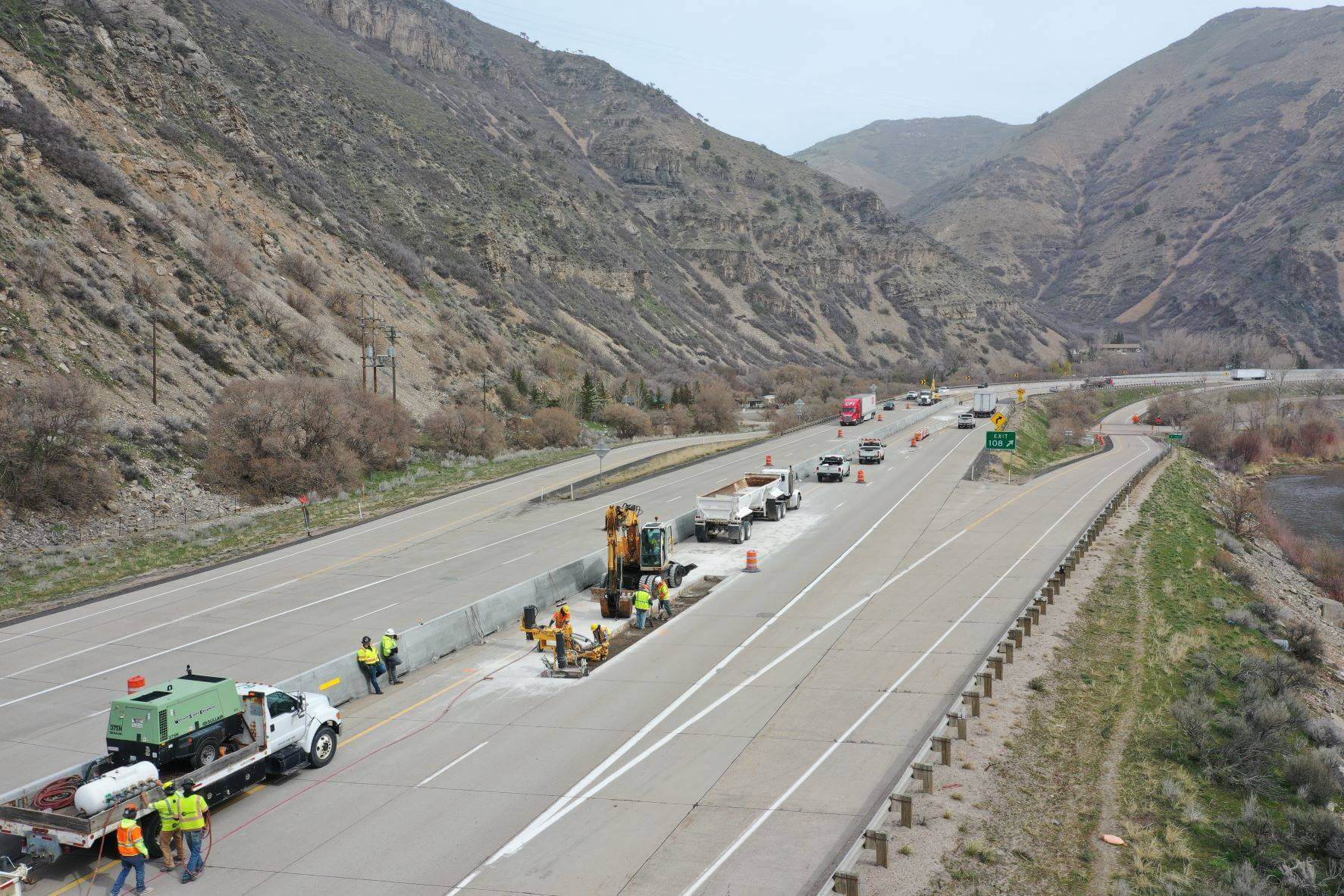 An aerial view of a highway in Utah, with mountains surrounding it