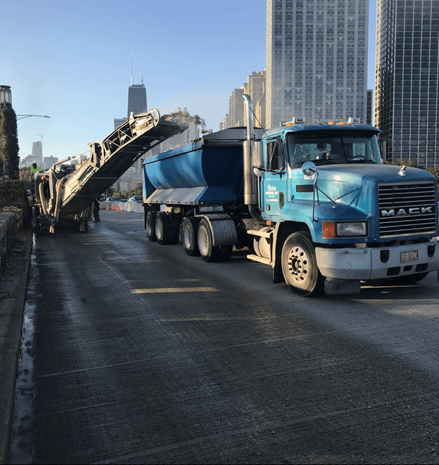 A blue Mack truck with buildings in the background, located in Chicago