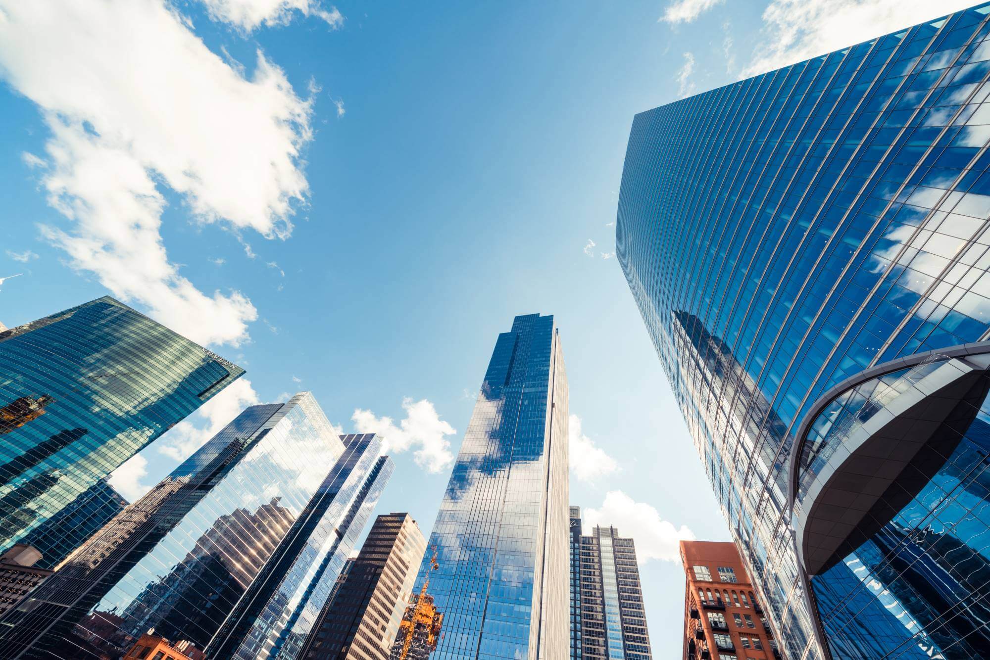 A photograph taken from below, looking up at a group of reflective buildings