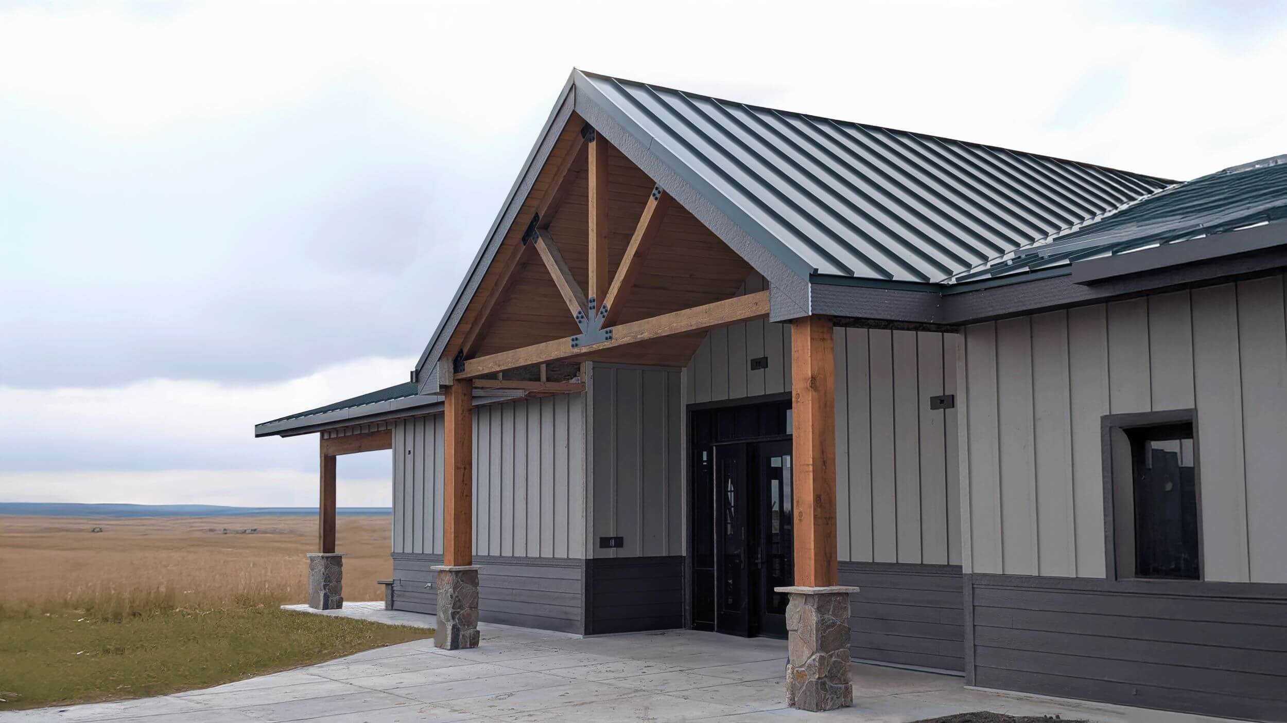 A gray building with a field in the background