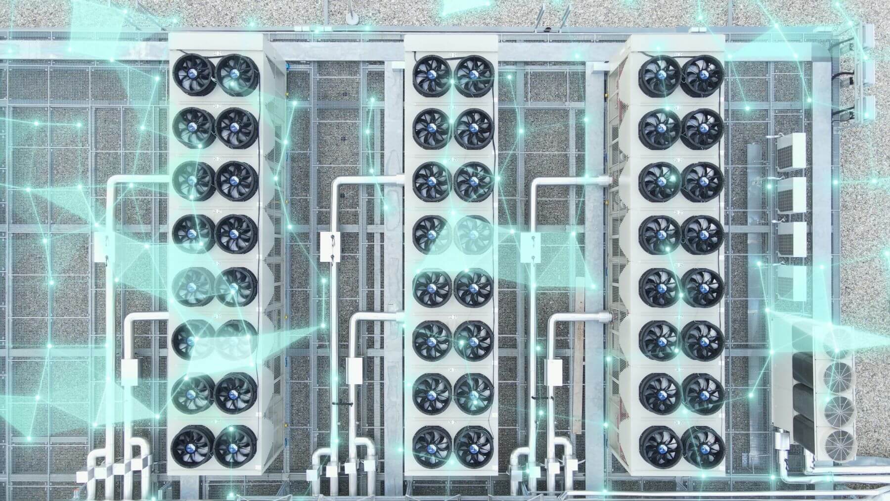 Aerial view of rooftop cooling and ventilation systems on a large data center, showing rows of industrial HVAC units and fans used for temperature control